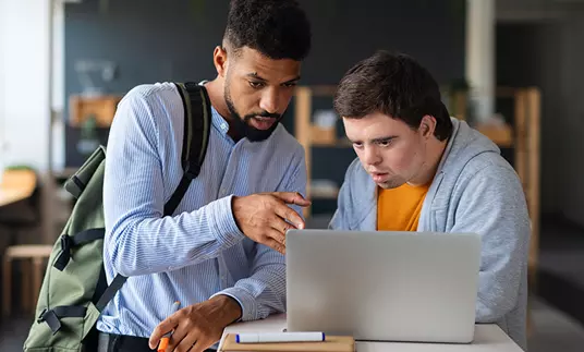 Two men in front of a notebook